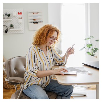 Woman sitting at table doing bills